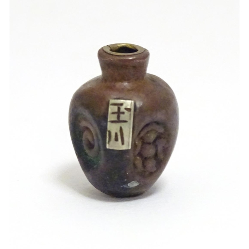 865 - A Japanese ojime bead formed as a stylised vase with impressed detail and applied brass character ma... 