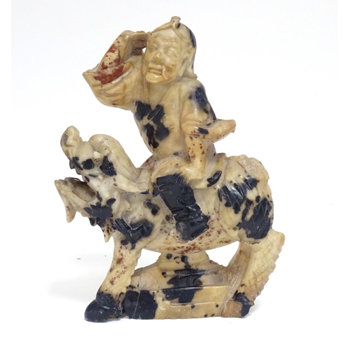 870 - A Chinese soapstone model of a figure riding a Qilin style creature. Approx. 5 1/2