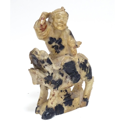 870 - A Chinese soapstone model of a figure riding a Qilin style creature. Approx. 5 1/2