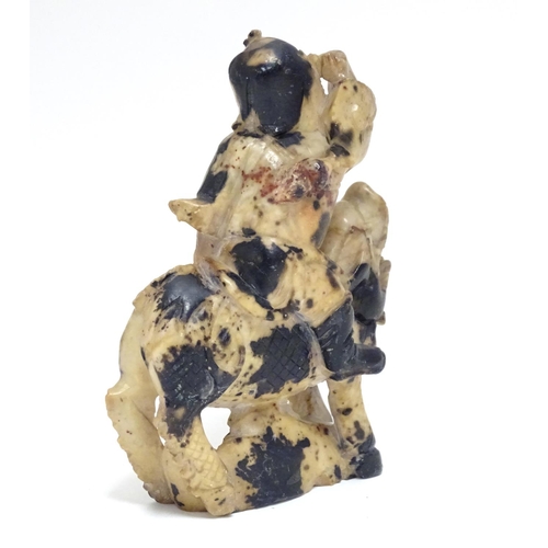 870 - A Chinese soapstone model of a figure riding a Qilin style creature. Approx. 5 1/2