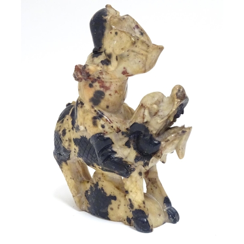 870 - A Chinese soapstone model of a figure riding a Qilin style creature. Approx. 5 1/2