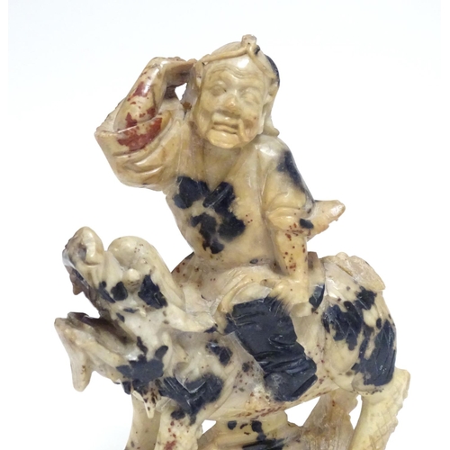 870 - A Chinese soapstone model of a figure riding a Qilin style creature. Approx. 5 1/2