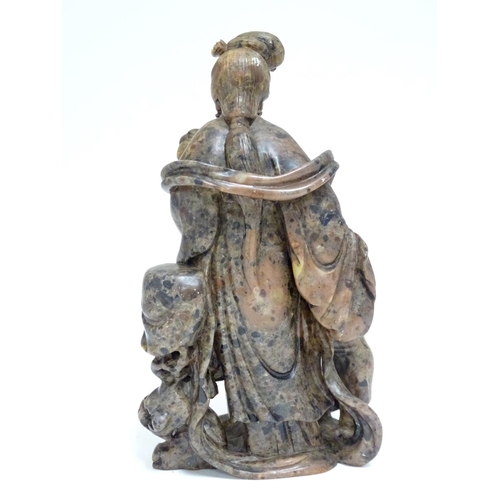 871 - A Chinese carved soapstone figural group modelled as Guanyin and a child, the goddess  holding a flo... 