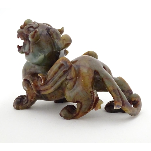 874 - A Chinese carved soapstone model of a stylised foo dog. Approx. 4 1/4