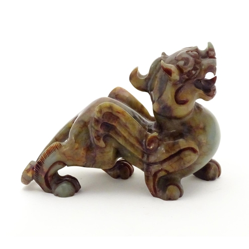 874 - A Chinese carved soapstone model of a stylised foo dog. Approx. 4 1/4