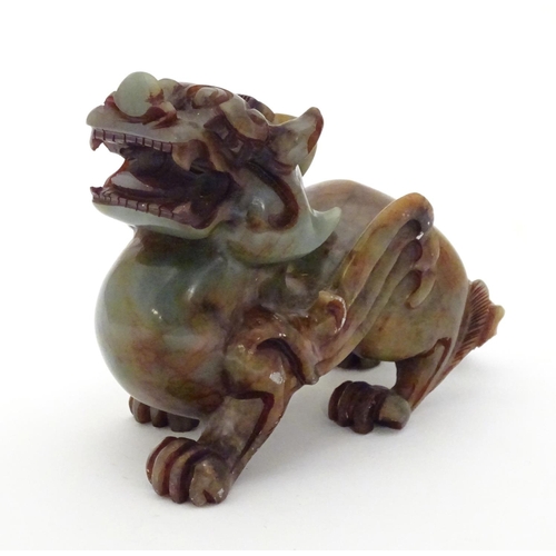 874 - A Chinese carved soapstone model of a stylised foo dog. Approx. 4 1/4