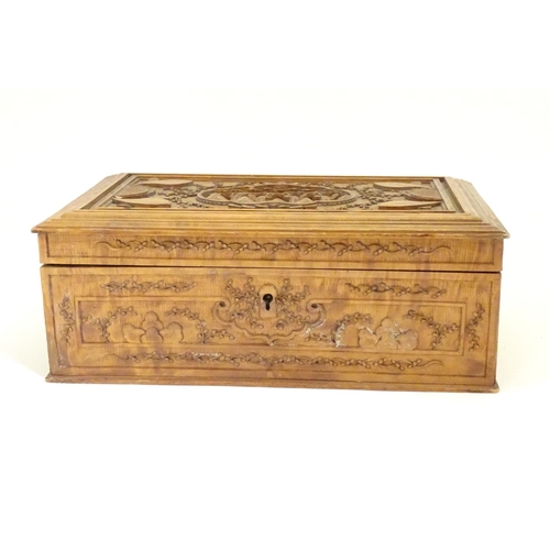 877 - A camphor wood box with carved floral and foliate detail, the lid with a carved vignette depicting a... 