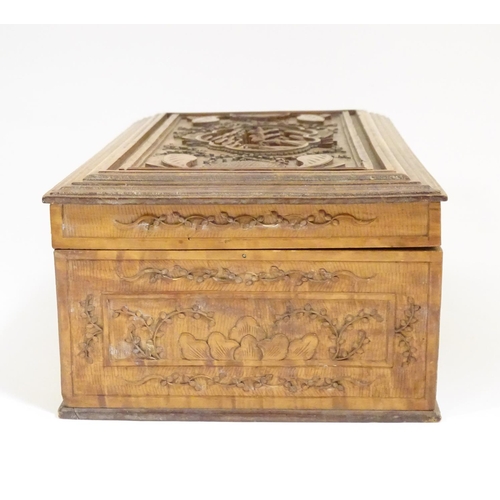 877 - A camphor wood box with carved floral and foliate detail, the lid with a carved vignette depicting a... 