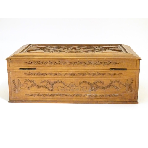 877 - A camphor wood box with carved floral and foliate detail, the lid with a carved vignette depicting a... 