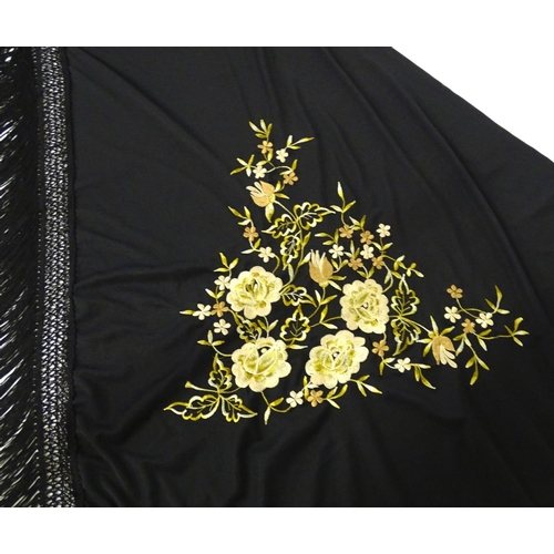 881 - A Victorian black fringed shawl with floral embroidery.