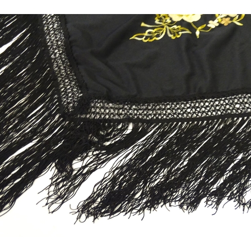 881 - A Victorian black fringed shawl with floral embroidery.