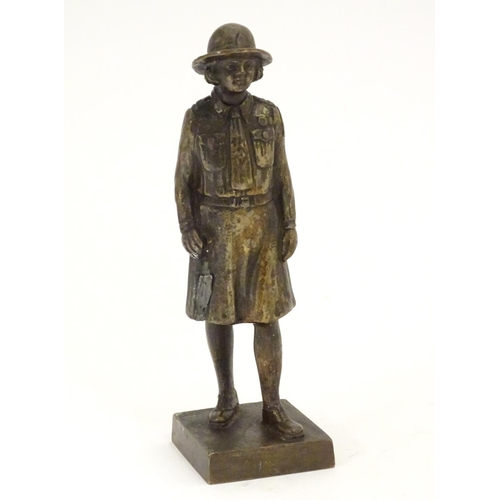 887 - A 20thC cast bronze model of a Girl Guide wearing a hat and uniform, on a square base. Approx. 6