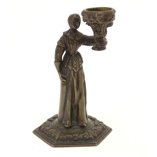 889 - A 19thC cast bronze figure of a woman holding a vase aloft on a hexagonal base with foliate decorati... 