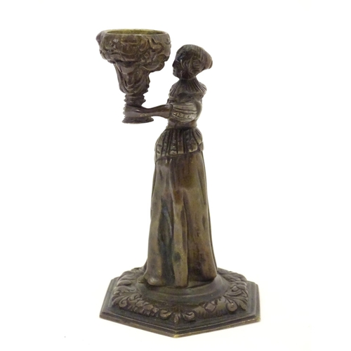 889 - A 19thC cast bronze figure of a woman holding a vase aloft on a hexagonal base with foliate decorati... 