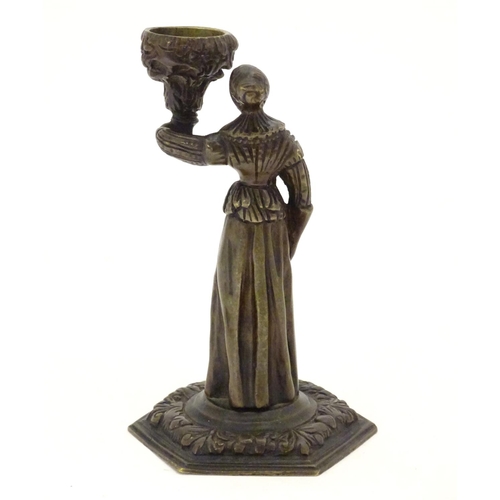 889 - A 19thC cast bronze figure of a woman holding a vase aloft on a hexagonal base with foliate decorati... 