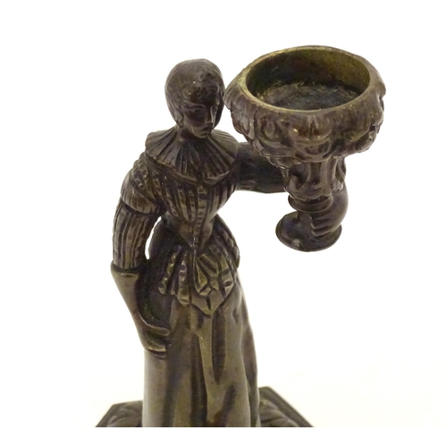 889 - A 19thC cast bronze figure of a woman holding a vase aloft on a hexagonal base with foliate decorati... 