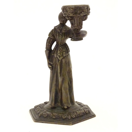 889 - A 19thC cast bronze figure of a woman holding a vase aloft on a hexagonal base with foliate decorati... 