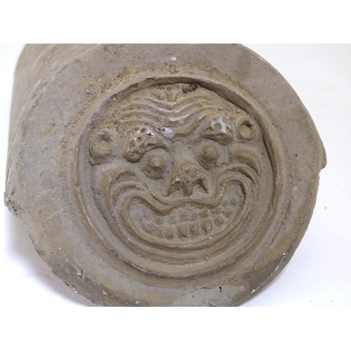 898 - A decorative Chinese style pottery roof ridge tile with circular end piece moulded with a stylised s... 