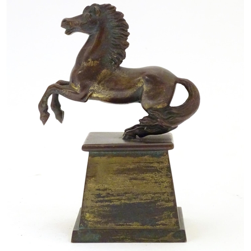 902 - An early 20thC bronze model of a rearing horse, on a tapered plinth base. Approx. 5 3/4