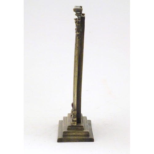 906 - A late 19th / early 20thC brass table top thermometer with a fahrenheit scale within an architectura... 