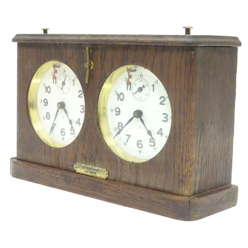 1183 - A 1920's / 30's oak cased chess clock by HAC Hamburg American Clock Company with crossed arrows trad... 