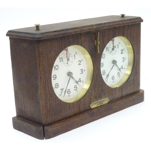 1183 - A 1920's / 30's oak cased chess clock by HAC Hamburg American Clock Company with crossed arrows trad... 