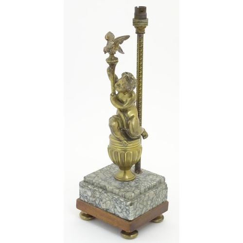 1215 - A 20thC table lamp decorated with cast figure of a putto holding aloft a bird, mounted upon a square... 