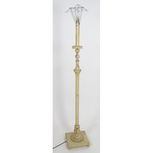 1221 - A carved and painted wooded standard lamp with reeded column on a squared base. Approx 60