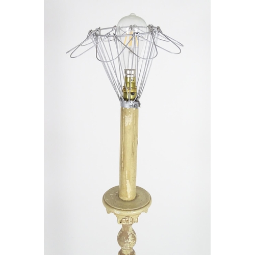 1221 - A carved and painted wooded standard lamp with reeded column on a squared base. Approx 60