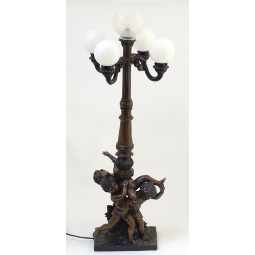 1223 - A 20thC bronze lamp with 5 glass globe shades. , the central column supported by putti. the whole ap... 