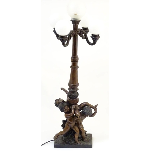 1223 - A 20thC bronze lamp with 5 glass globe shades. , the central column supported by putti. the whole ap... 