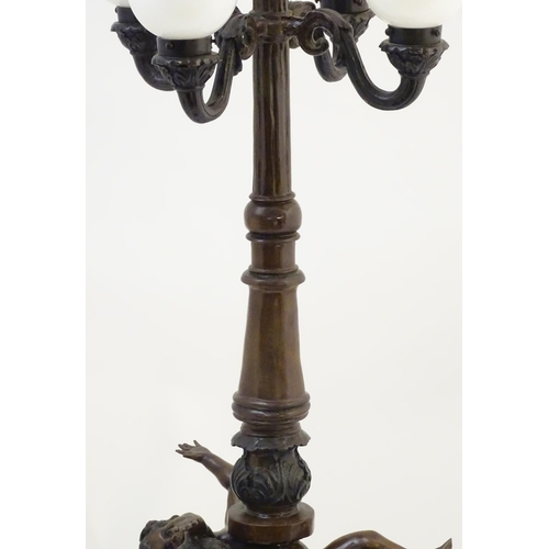 1223 - A 20thC bronze lamp with 5 glass globe shades. , the central column supported by putti. the whole ap... 