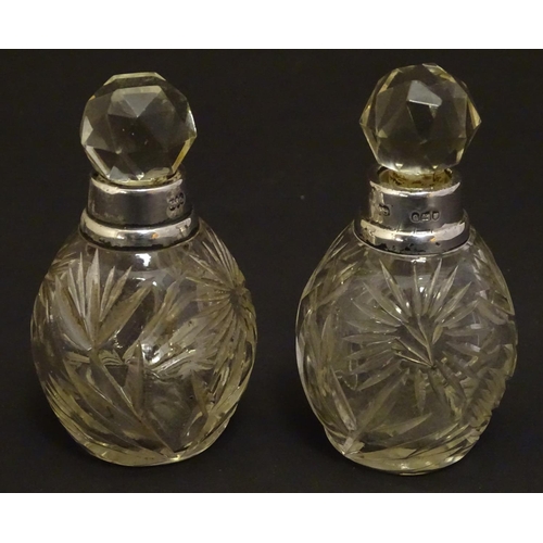 151 - A pair cut glass scene / perfume bottles with silver collars . Hallmarked London 1911 maker Hart & s... 