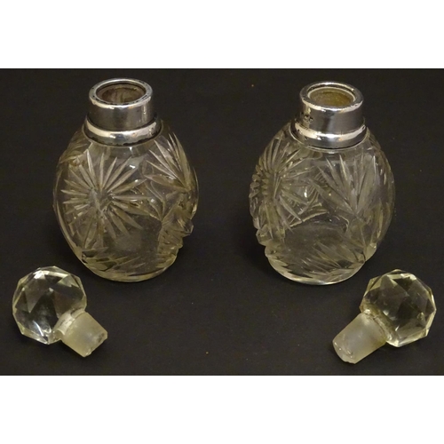 151 - A pair cut glass scene / perfume bottles with silver collars . Hallmarked London 1911 maker Hart & s... 