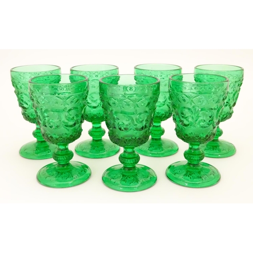 160 - A set of 7 vintage green glass  pedestal glasses with moulded decoration . Approx 4