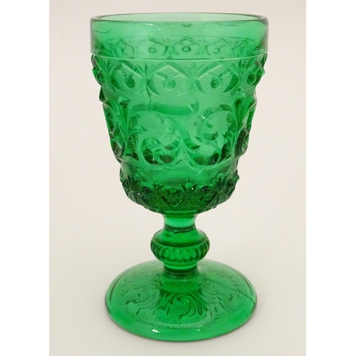 160 - A set of 7 vintage green glass  pedestal glasses with moulded decoration . Approx 4