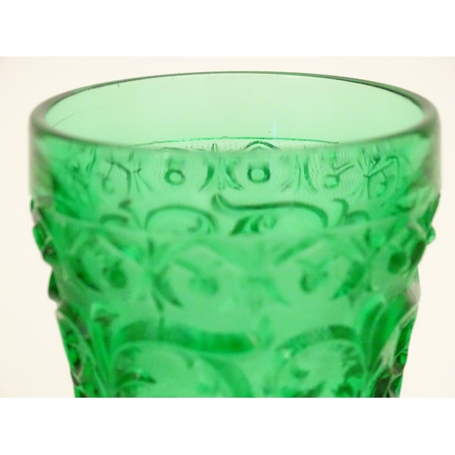 160 - A set of 7 vintage green glass  pedestal glasses with moulded decoration . Approx 4