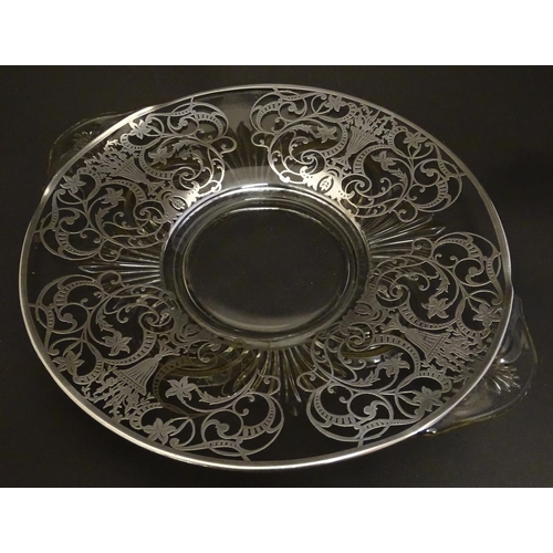 172 - A glass twin handled fruit dish / plate with silvered overlay decoration Approx. 13