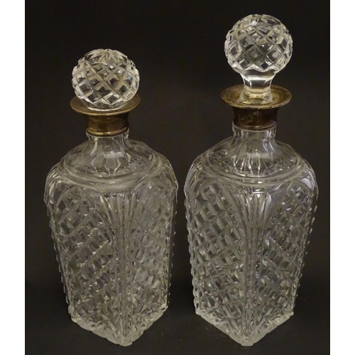 179 - Two cut glass decanters with silver collars. Hallmarked London 1934. Approx 9