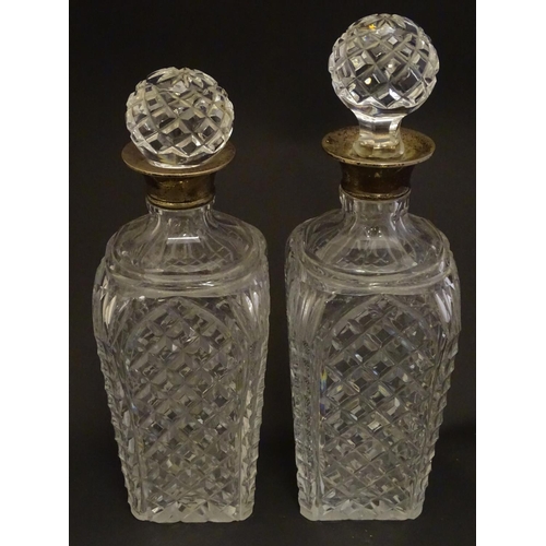 179 - Two cut glass decanters with silver collars. Hallmarked London 1934. Approx 9