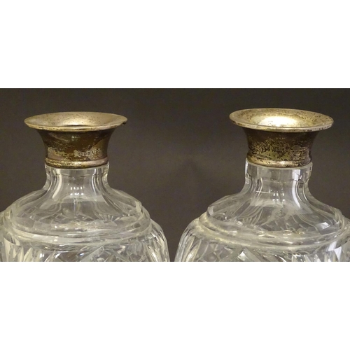 179 - Two cut glass decanters with silver collars. Hallmarked London 1934. Approx 9