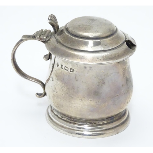 209 - A silver mustard pot on stepped base, with blue glass liner within. Hallmarked Birmingham 1921 maker... 