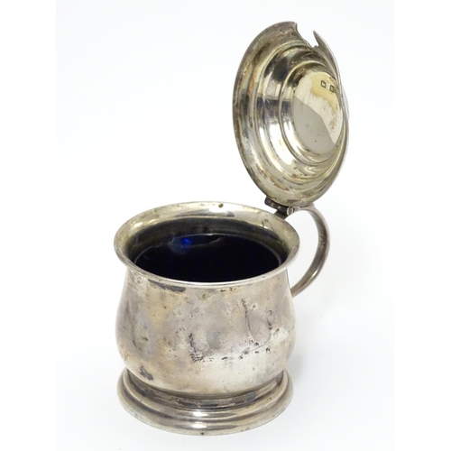 209 - A silver mustard pot on stepped base, with blue glass liner within. Hallmarked Birmingham 1921 maker... 