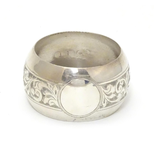 214 - A silver napkin ring with engraved acanthus scroll decoration. Hallmarked Birmingham 1921 maker Jose... 