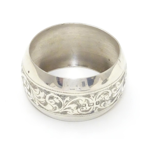 214 - A silver napkin ring with engraved acanthus scroll decoration. Hallmarked Birmingham 1921 maker Jose... 