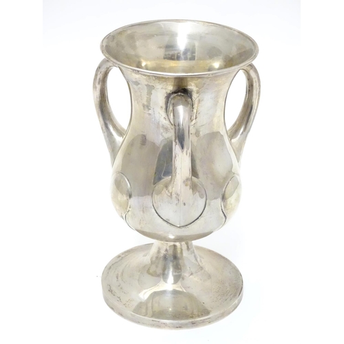 218 - An Art Nouveau silver pedestal  trophy cup with three handles. hallmarked Birmingham 1902 maker Nort... 