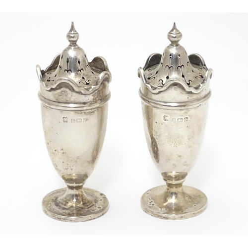 227 - A pair of silver pepperettes with wavy-edged rims. Hallmarked Birmingham 1923 maker Martin Hall & Co... 