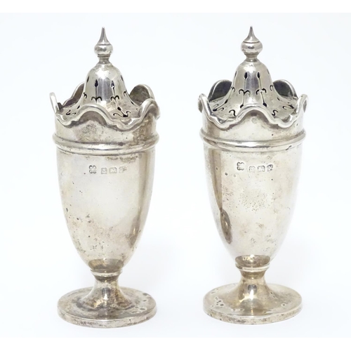 227 - A pair of silver pepperettes with wavy-edged rims. Hallmarked Birmingham 1923 maker Martin Hall & Co... 