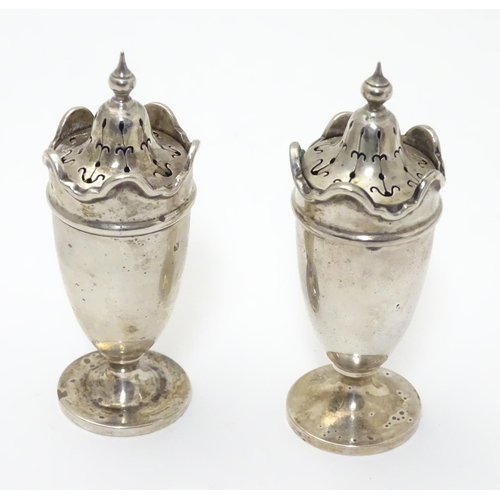 227 - A pair of silver pepperettes with wavy-edged rims. Hallmarked Birmingham 1923 maker Martin Hall & Co... 