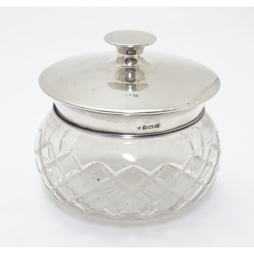 229 - A cut glass powder bowl with silver lid hallmarked Birmingham 1922 maker Charles S Green & Co Ltd. A... 